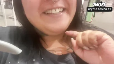 Uma mulher BBW se exibindo no provador de uma loja de roupas em público.